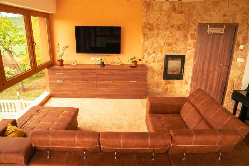 Obyvacka s rozkladaciou pohovko, kozubom a klavirom.